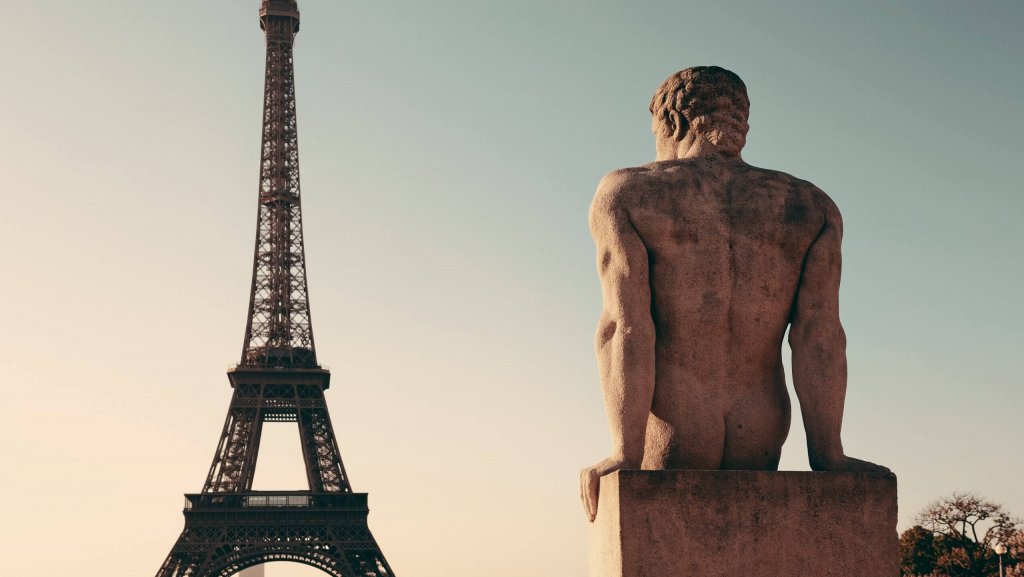 Eiffel Tower with statue as the famous city landmark in Paris