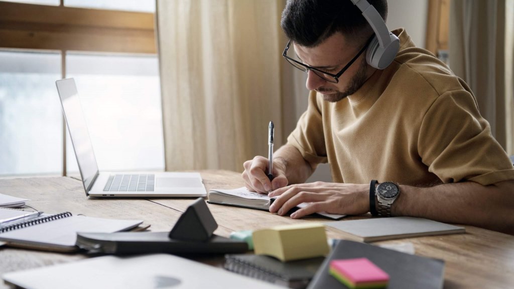 Young man writing in his notebook